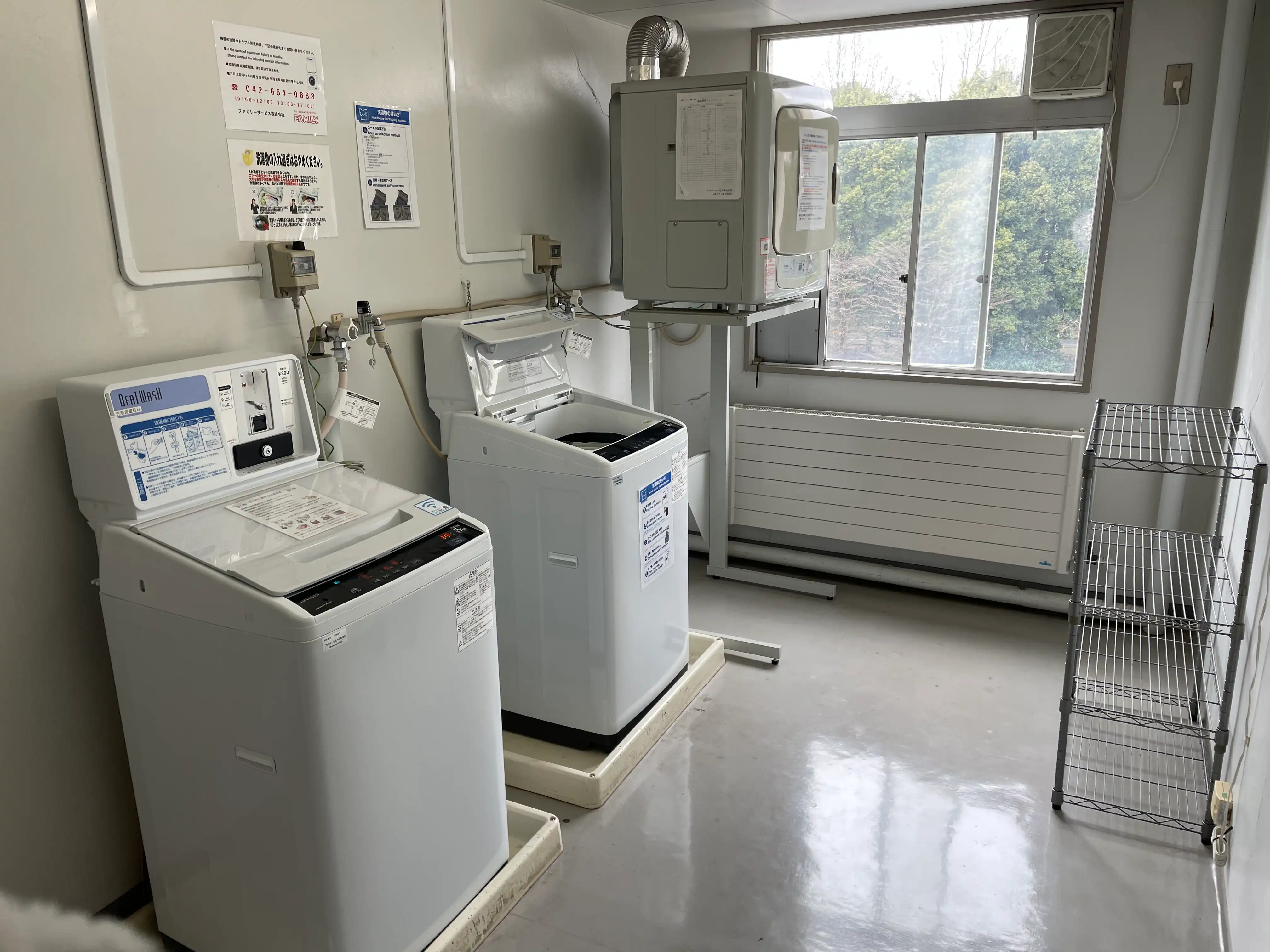 洗濯室の画像。コイン洗濯機が2つ、ガス乾燥機が1つ設置されている